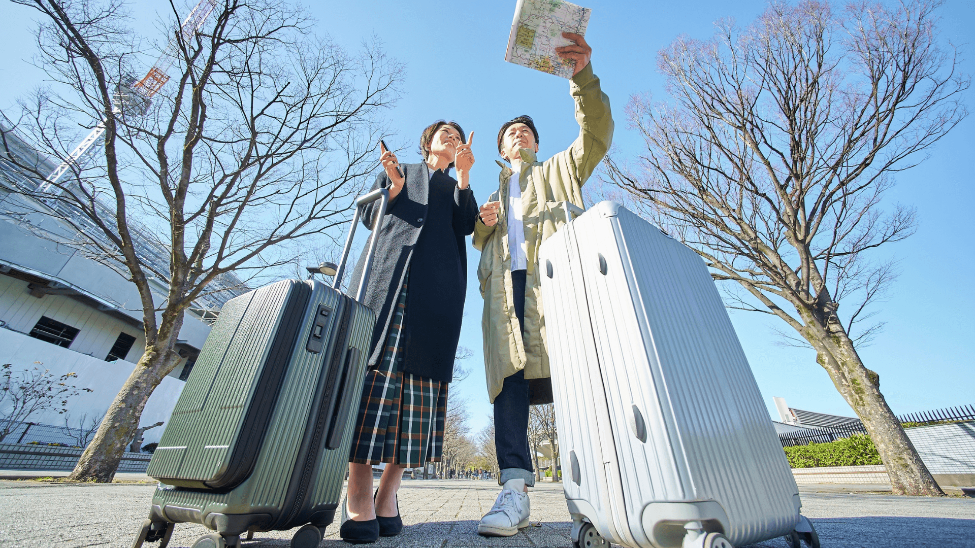 Traveling Couple Checking Map with Luggage